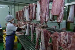 Phân loại thịt lợn đã chế biến và treo trên giá đảm bảo an toàn vệ sinh thực phẩm. (Ảnh: Vũ Sinh/TTXVN)