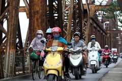 Người dân với trang phục áo ấm đi trên cầu Long Biên (Hà Nội). (Ảnh: Danh Lam/TTXVN)