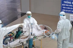 Vận chuyển BN8944 lên khu vực điều trị của Bệnh viện Chợ Rẫy. (Ảnh: TTXVN phát)