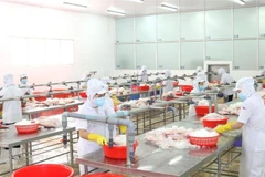 Thực hiện giãn cách trong khu vực chế biến thủy sản. (Ảnh: Xuân Anh/TTXVN)