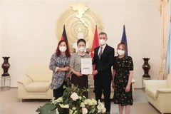 Đại sứ Nguyễn Minh Vũ tiếp nhận số tiền của Hội người Hải Phòng tại CHLB Đức ủng hộ công tác phòng, chống dịch COVID-19 ở Việt Nam. (Ảnh: Mạnh Hùng/TTXVN)