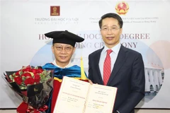 Tổng Lãnh sự Việt Nam tại Hong Kong Phạm Bình Đàm (phải) thay mặt Trường Đại học Hà Nội trao bằng Tiến sỹ danh dự cho ông Lâm Kiến Trung, Chủ tịch Tập đoàn Zhang Yang Group HoldingsLtd Hong Kong. (Ảnh: TTXVN)