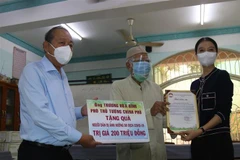 Phó Thủ tướng Trương Hòa Bình thăm hỏi và trao quà cho người dân là đồng bào dân tộc Chăm tại Quận 8, TP. Hồ Chí Minh. (Ảnh: Quang Châu/TTXVN)