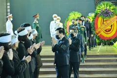 Phó Thủ tướng Thường trực Chính phủ Phạm Bình Minh chia buồn cùng thân quyến gia đình đồng chí Vũ Oanh. (Ảnh: Minh Đức/TTXVN)