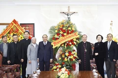 Chủ tịch nước Nguyễn Xuân Phúc tặng hoa chúc mừng Toà Tổng Giám mục Hà Nội Tổng giáo phận Hà Nội. (Ảnh: Thống Nhất/TTXVN)