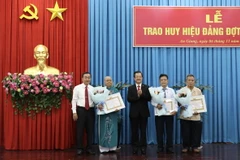 Lãnh đạo Tỉnh ủy An Giang trao tặng Huy hiệu 55 năm tuổi Đảng cho các đảng viên cao niên tuổi Đảng. (Ảnh: Thanh Sang/TTXVN)