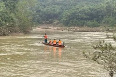 Lực lượng chức năng dùng xuồng máy tìm kiếm các nạn nhân. (Ảnh: TTXVN phát)