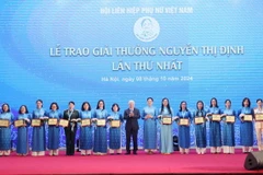 Chủ tịch Ủy ban Trung ương Mặt trận Tổ quốc Việt Nam Đỗ Văn Chiến và Chủ tịch Hội Liên hiệp Phụ nữ Việt Nam Hà Thị Nga trao Giải thưởng Nguyễn Thị Định cho các cá nhân tiêu biểu. (Ảnh: Phương Hoa/TTXVN)