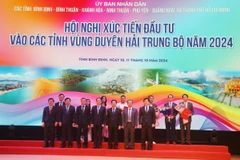 Lãnh đạo Ủy ban Nhân dân tỉnh Bình Định trao tặng quyết định chủ trương, giấy chứng nhận đầu tư cho các doanh nghiệp. (Ảnh: Sỹ Thắng/TTXVN)