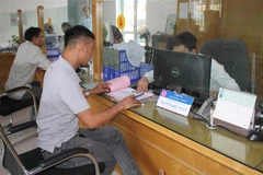 Người dân làm thủ tục hành chính tại bộ phận một cửa UBND thành phố Ninh Bình. (Ảnh: Hải Yến/TTXVN)