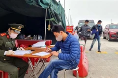 Lực lượng chức năng làm nhiệm vụ hướng dẫn, phân luồng giao thông, khai báo y tế tại chốt trạm cầu Bạch Đằng, thị xã Quảng Yên. (Ảnh: TTXVN)