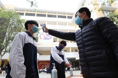 Trường THPT Trần Nhân Tông, quận Hai Bà Trưng (Hà Nội) thực hiện đo thân nhiệt, sát khuẩn tay cho cán bộ, giáo viên và học sinh mỗi khi ra, vào trường. (Ảnh: Thanh Tùng/TTXVN)