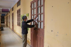 Tiến hành dán niêm phong phòng học. (Ảnh: Mạnh Minh/TTXVN)