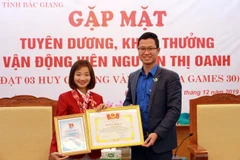 Đại diện Tỉnh đoàn Bắc Giang trao tặng bằng khen cho vận động viên Nguyễn Thị Oanh. (Ảnh: Đồng Thúy/TTXVN)