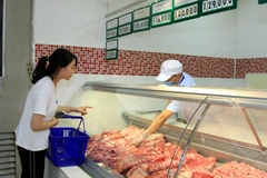 Khách hàng chọn mua thịt lợn tại siêu thị Co.opmart Hà Đông (Hà Nội). (Ảnh: TTXVN)