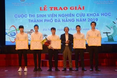 Ban tổ chức trao giải nhất cho nhóm tác giả có đề tài 'Thiết kế thủy bộ thu gom rác bãi biển'. (Ảnh: Văn Dũng/TTXVN)