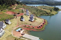 Dãy nhà gỗ dựng sát mép nước, xâm phạm vùng bảo vệ 1 của Di tích thắng cảnh quốc gia hồ Tuyền Lâm. (Ảnh: Đặng Tuấn/TTXVN)