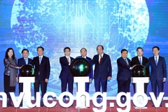 Thủ tướng Nguyễn Xuân Phúc và các đại biểu thực hiện nghi thức khai trương Cổng Dịch vụ công Quốc gia. (Ảnh: Thống Nhất/TTXVN)