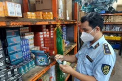 Lực lượng Quản lý thị trường kiểm tra một cửa hàng kinh doanh phụ tùng xe máy tại chợ Tân Thành, phường 12, quận 5, Thành phố Hồ Chí Minh. (Ảnh: PV/Vietnam+)