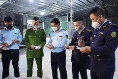 Lực lượng chức năng kiểm tra lô hàng kit test COVID-19 và các hàng hóa liên quan. (Ảnh: PV/Vietnam)
