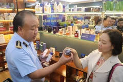 Ông Trần Hữu Linh, Tổng Cục trưởng Tổng cục Quản lý thị trường hướng dẫn cách nhận biết một số sản phẩm bị làm giả. (Ảnh: Minh Anh/Vietnam+)