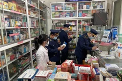 Lực lượng Quản lý thị trường kiểm tra các mặt hàng thuốc và thiết bị y tế phòng chống dịch. (Ảnh: PV/Vietnam+)