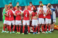 Các tuyển thủ Đan Mạch đứng vòng quanh trong quá trình bác sỹ hỗ trợ cho tiền vệ Christian Eriksen khi anh ngã gục trên sân trong trận gặp đội Phần Lan ở bảng B, EURO 2020 trên sân Parken, Copenhagen ngày 12/6/2021. (Ảnh: AFP/TTXVN)