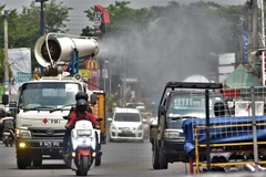Nhân viên Chữ Thập Đỏ phun thuốc khử trùng nhằm ngăn chặn sự lây lan của dịch COVID-19 ở Bekasi (Indonesia), ngày 9/8/2021. (Ảnh: AFP/TTXVN)