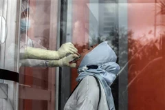 Nhân viên y tế lấy mẫu xét nghiệm COVID-19 tại Medan (Indonesia). (Ảnh: THX/TTXVN)