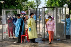 Người dân được khử khuẩn trước khi vào tiêm chủng vaccine ngừa COVID-19 tại Phnom Penh, Campuchia, ngày 20/5/2021. (Ảnh: AFP/TTXVN)