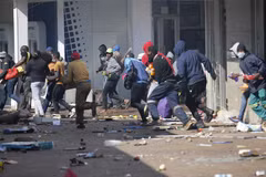 Các đối tượng cướp phá tại một cửa hàng ở Johannesburg (Nam Phi) ngày 12/7/2021. (Ảnh: AFP/TTXVN)