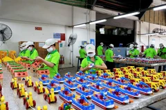 Công nhân làm đồ chơi trẻ em bằng gỗ tại Công ty Gỗ Đức Thành. (Ảnh: Hồng Đạt/TTXVN)