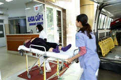 Nhân viên y tế vận chuyển người bệnh. (Ảnh: Dương Ngọc/TTXVN)