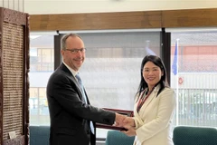 Phó Tổng Kiểm toán Nhà nước Hà Thị Mỹ Dung tặng quà Tổng Kiểm toán Nhà nước New Zealand John Ryan. (Ảnh: Văn Linh/TTXVN)