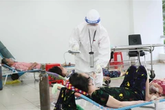 Các bác sỹ thăm khám bệnh nhân nhiễm COVID-19 không triệu chứng có bệnh nền. (Ảnh: Xuân Khu/TTXVN)