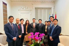 Đại sứ Đặng Hoàng Giang (thứ 5 từ trái qua) chúc mừng Tết cổ truyền Bunpimay với Đại sứ Anouparb Vongnorkeo (thứ 5 từ phải qua). (Ảnh: TTXVN phát)