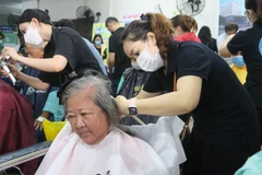 Cắt tóc, gội đầu miễn phí cho bệnh nhân tại Chương trình “Chủ nhật chia sẻ yêu thương.” (Ảnh: Đinh Hằng/TTXVN)