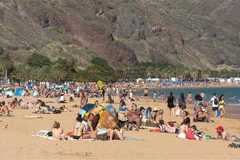 Người dân tránh nóng trên bãi biển ở Santa Cruz de Tenerife, Tây Ban Nha. (Ảnh: AFP/TTXVN)