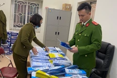 Cơ quan công an kiểm tra số khẩu trang nhập lậu. (Ảnh: PV/Vietnam+) 