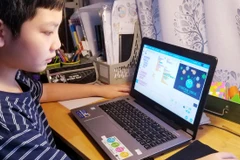 Bé Minh Khang bên trò chơi do chính mình thiết kế. (Ảnh: Thành đoàn Hà Nội) 