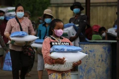 Bà con cộng đồng người gốc Việt và Khmer có hoàn cảnh khó khăn do ảnh hưởng của dịch COVID-19 nhận hỗ trợ. (Ảnh: Nguyễn Vũ Hùng/TTXVN)