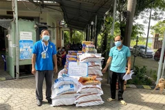 Đại diện Công đoàn các Khu chế xuất, Khu công nghiệp thành phố tặng lương thực, thực phẩm và đồ dùng thiết yếu cho công nhân lao động ở khu lưu trú Hiệp Phước, huyện Nhà Bè. (Ảnh: Thanh Vũ/TTXVN)