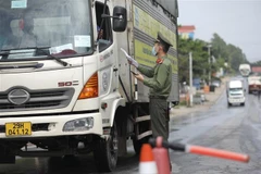 Lực lượng chức năng tại chốt kiểm soát đầu cầu Trung Hà (huyện Ba Vì, Hà Nội) kiểm tra giấy tờ của người và phương tiện khi qua chốt. (Ảnh: Minh Quyết/TTXVN)