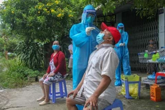 Lấy mẫu xét nghiệm COVID-19 tận nhà cho người dân quận Ninh Kiều. (Ảnh: Thanh Liêm/TTXVN)