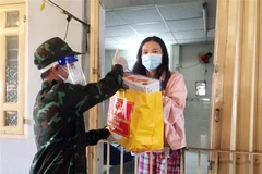 Những gói quà của Bộ Quốc phòng được cán bộ, chiến sỹ lực lượng vũ trang Thành phố trao tận tay người dân gặp khó khăn do dịch COVID-19 tại Quận 8, Thành phố Hồ Chí Minh. (Ảnh: Xuân Khu/TTXVN)