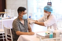 Nhân viên y tế tiêm vaccine phòng COVID-19 cho người dân quận Hoàn Kiếm, chiều 15/9. (Ảnh: Minh Quyết/TTXVN)
