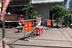 Tiếp tế lương thực cho người dân trong khu vực bị phong tỏa tại tổ 18, khu vực 4, phường Hải Cảng, TP. Quy Nhơn. (Ảnh: Nguyên Linh/TTXVN)