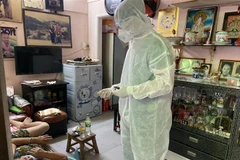 Lực lượng Quân y thăm khám cho một cụ bà F0 ở Khu phố 1, Phường 6. (Ảnh: Mạnh Linh/TTXVN)