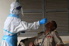 Nhân viên y tế lấy mẫu xét nghiệm COVID-19 cho người dân tại Phnom Penh, Campuchia ngày 16/8. (Ảnh: AFP/TTXVN)