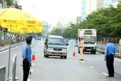 Lực lượng chức năng kiểm tra và kiểm soát toàn bộ phương tiện giao thông tại chốt kiểm dịch số 3, lối lên cầu Chương Dương. (Ảnh: Phạm Kiên/TTXVN)